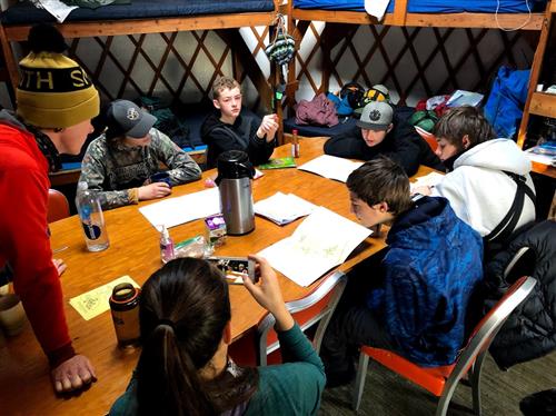 students in a yurt working together 