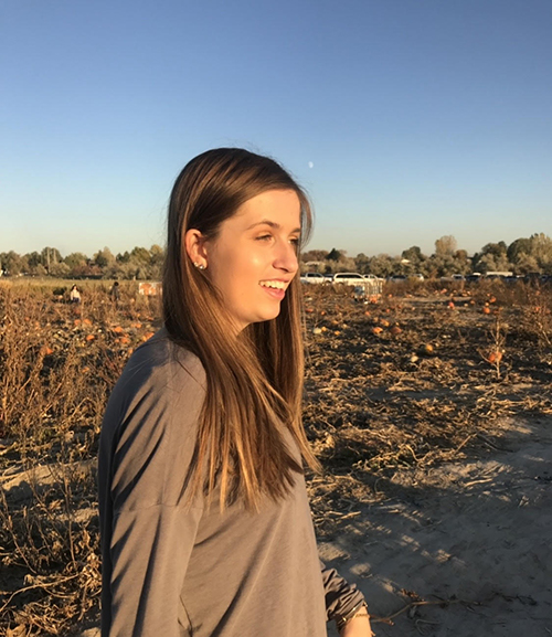 photo of Brittany Williamson standing in a pumpkin patch and smiling 