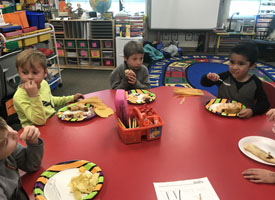  students eating at round red table in classroom