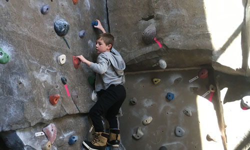 boy climbing wall at the YMCA 