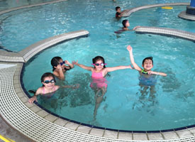  students in swimming pool with goggles
