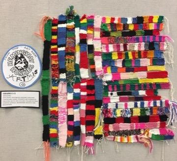 This image shows all of the student weaving samples on display collectively. Together it appears to resemble a super colorful QR code.